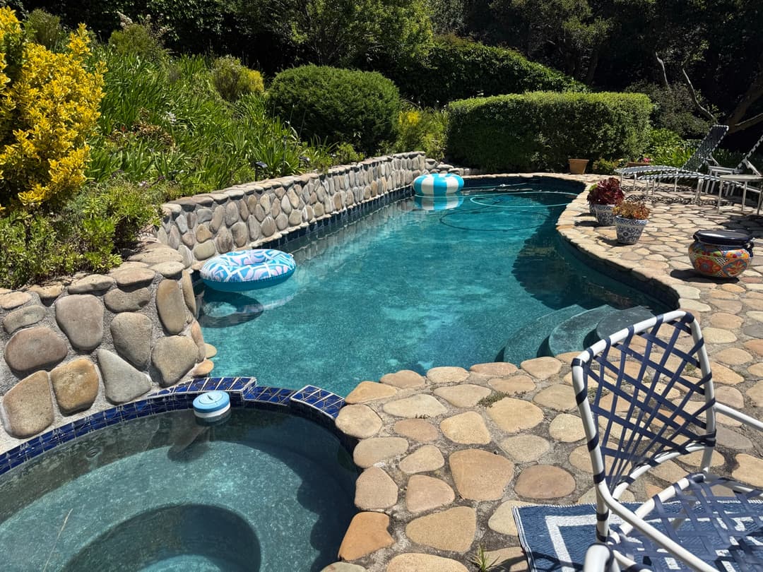 Residential pool with river rock coping and attached spa with crystal clear water after weekly pool service in Marin County CA
