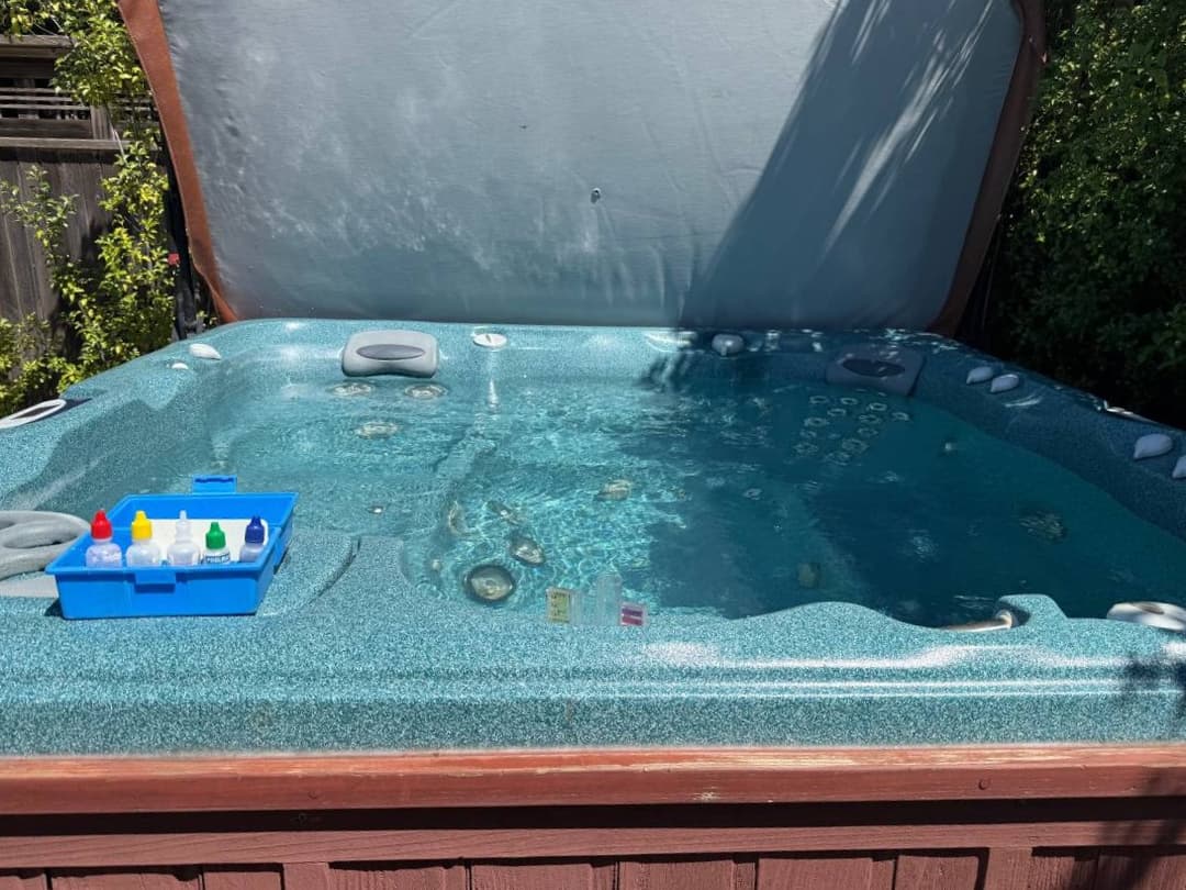 Pool water treatment and surface cleaning in progress during maintenance visit